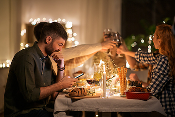 Image showing man with smartphone at dinner party with friends