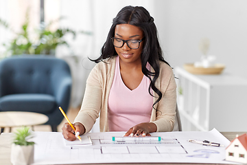 Image showing female architect with house model and blueprint