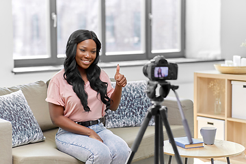 Image showing female blogger with camera video blogging at home