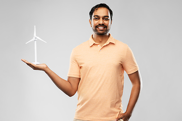 Image showing smiling young man with toy wind turbine