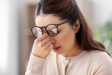 Image showing tired woman with glasses rubbing her nose bridge