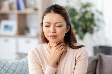 Image showing sick asian woman with sore throat at home