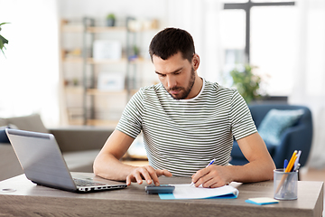 Image showing man with files and calculator works at home office