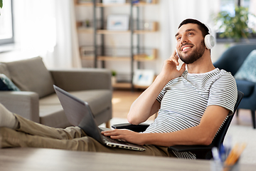 Image showing happy man with laptop and headphones at home