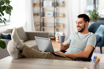 Image showing happy man with laptop drinking coffee at home