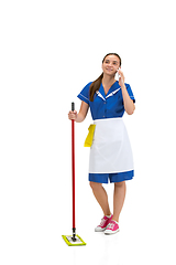 Image showing Portrait of female made, cleaning worker in white and blue uniform isolated over white background