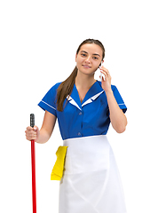 Image showing Portrait of female made, cleaning worker in white and blue uniform isolated over white background