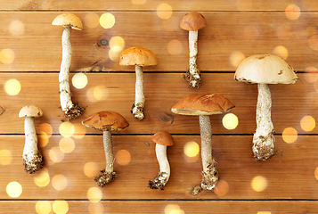 Image showing brown cap boletus mushrooms on wooden background