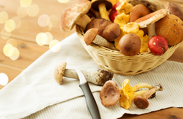 Image showing basket of different edible mushrooms and knife