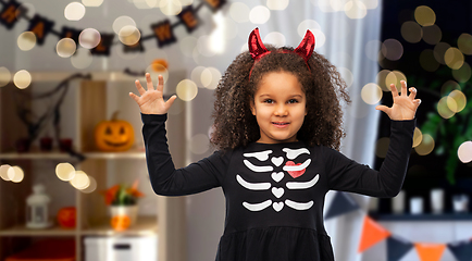 Image showing girl in black dress and devil's horns on halloween