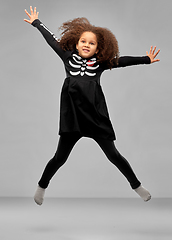 Image showing girl in halloween costume of skeleton jumping