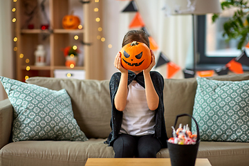 Image showing girl in halloween costume with pumpkin at home