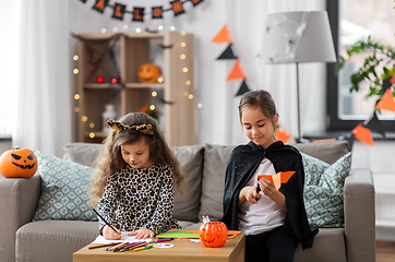 Image showing girls in halloween costumes doing crafts at home