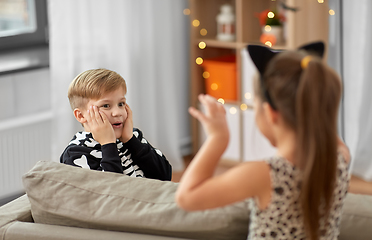 Image showing kids in halloween costumes playing at home