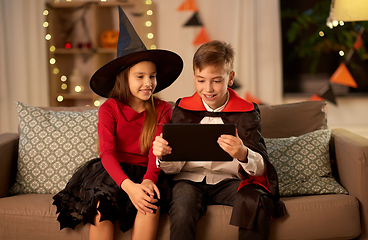 Image showing kids in halloween costumes with tablet pc at home