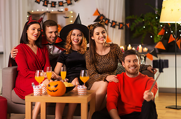 Image showing happy friends in halloween costumes taking selfie