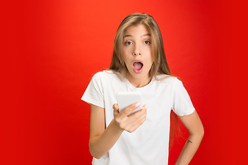 Image showing Portrait of young caucasian woman with bright emotions on bright red studio background