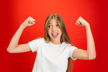 Image showing Portrait of young caucasian woman with bright emotions on bright red studio background