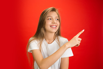 Image showing Portrait of young caucasian woman with bright emotions on bright red studio background