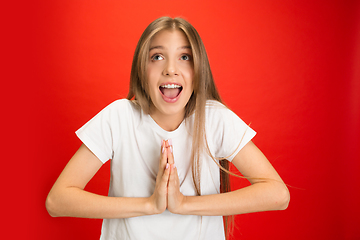 Image showing Portrait of young caucasian woman with bright emotions on bright red studio background