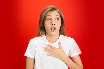 Image showing Portrait of young caucasian woman with bright emotions on bright red studio background