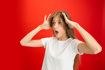 Image showing Portrait of young caucasian woman with bright emotions on bright red studio background