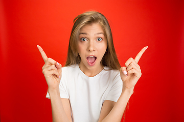 Image showing Portrait of young caucasian woman with bright emotions on bright red studio background