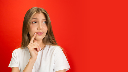 Image showing Portrait of young caucasian woman with bright emotions on bright red studio background