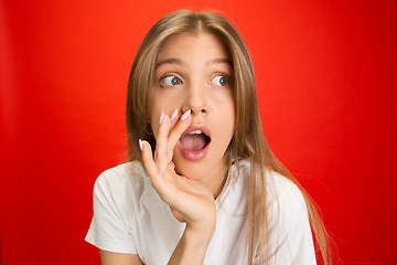 Image showing Portrait of young caucasian woman with bright emotions on bright red studio background