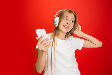 Image showing Portrait of young caucasian woman with bright emotions on bright red studio background