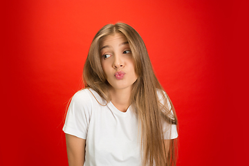 Image showing Portrait of young caucasian woman with bright emotions on bright red studio background