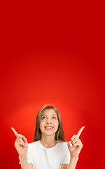 Image showing Portrait of young caucasian woman with bright emotions on bright red studio background