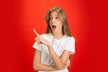 Image showing Portrait of young caucasian woman with bright emotions on bright red studio background