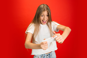 Image showing Portrait of young caucasian woman with bright emotions on bright red studio background