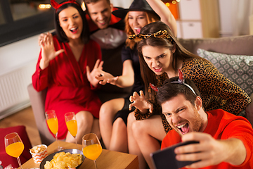 Image showing happy friends in halloween costumes taking selfie