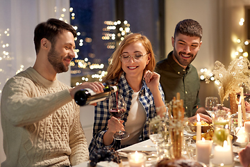 Image showing happy friends with red wine at christmas party