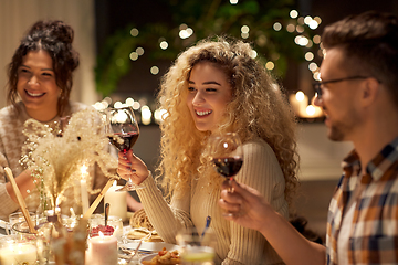 Image showing happy friends drinking red wine at christmas party