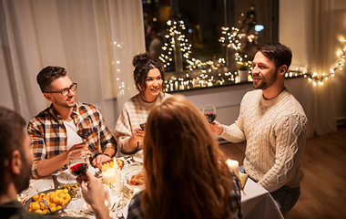 Image showing happy friends drinking red wine at christmas party