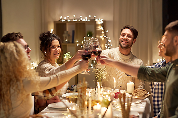 Image showing happy friends drinking red wine at christmas party