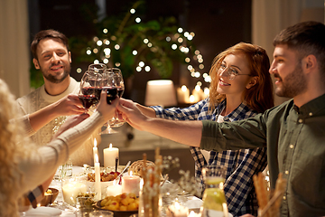 Image showing happy friends drinking red wine at christmas party