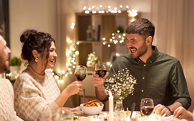 Image showing happy friends drinking red wine at christmas party