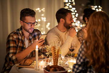 Image showing man with smartphone at dinner party with friends