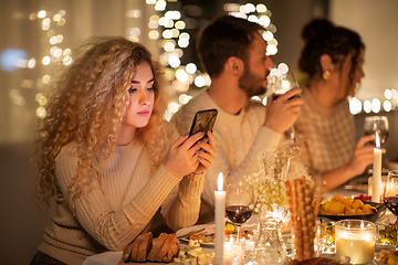 Image showing woman with smartphone at dinner party with friends