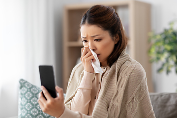 Image showing sick asian woman with smartphone at home