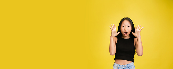 Image showing Portrait of young asian girl isolated on yellow studio background