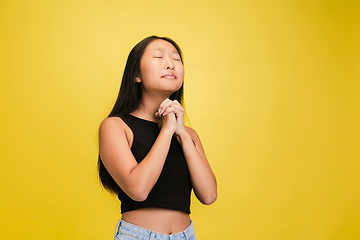 Image showing Portrait of young asian girl isolated on yellow studio background