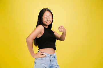 Image showing Portrait of young asian girl isolated on yellow studio background