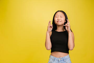 Image showing Portrait of young asian girl isolated on yellow studio background