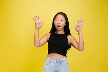 Image showing Portrait of young asian girl isolated on yellow studio background