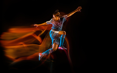 Image showing Football or soccer player on black background in mixed light, fire shadows